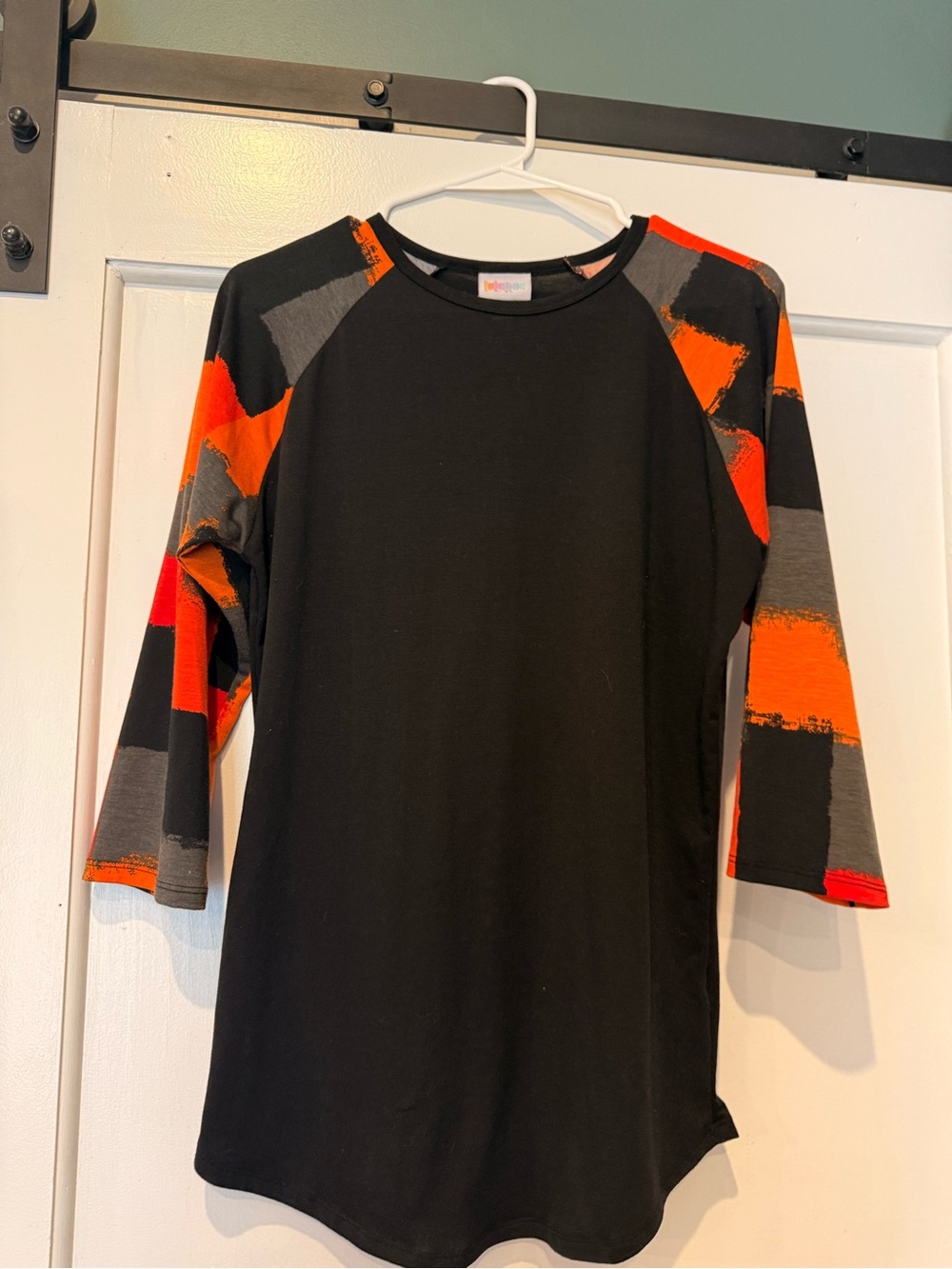 Women a Black Tunic with Orange & Gray Patterned Sleeves